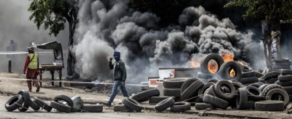 A protester walks past a burning barricade made of tyres during clashes with Kenya police officers at Saba Saba Day demonstrations in Nairobi on July 7, 2025. Photo: AP Photo
