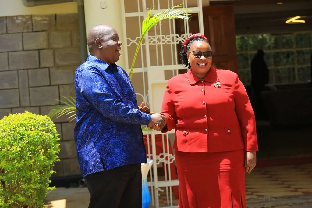 Fred Matiang'i shakes hands with Bishop Margaret Wanjiru. Photo/@margaretwanjirubmw/Facebook